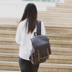 Hiking woman with backpack walking on a gravel road